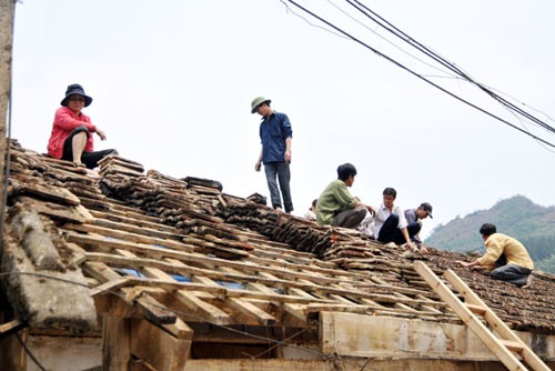 Gia đình chị Lui Hồng Chấn (34 tuổi) ở thôn Làn Ma, xã Tung Trung Phố, H.Mường Khương, Lào Cai đang khẩn trương lợp lại mái nhà. Không có nhiều gia đình đủ điều kiện làm lại mái nhà như chị Chấn - Ảnh: Tùng Lâm